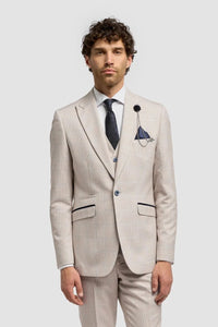 Man wearing a beige suit with a white shirt and brown shoes on a light gray background